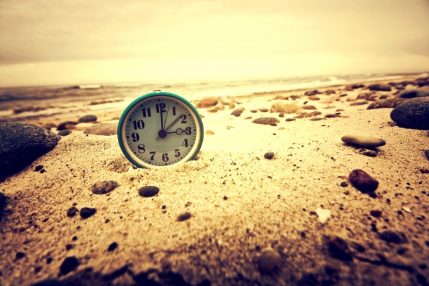 clock on the beach time and business concept 1204 346