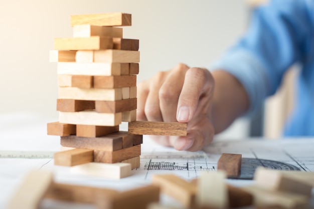 planning risk and strategy in business businessman and engineer gambling placing wooden block on a tower 1423 762