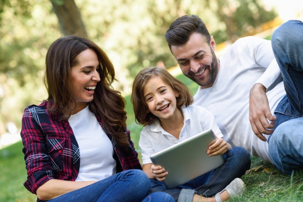 couple laughing with their daughter and a laptop 1139 620